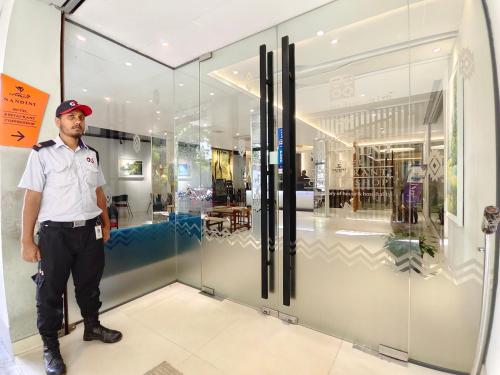 a man standing in front of a store window at Hotel Nandini in Dhaka