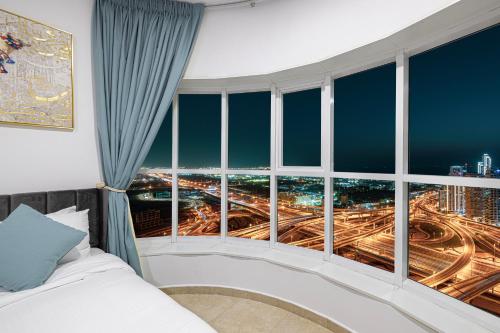 a bedroom with a large window with a city view at Stunning Panoramic Sea & Marina City Skyline View in Dubai