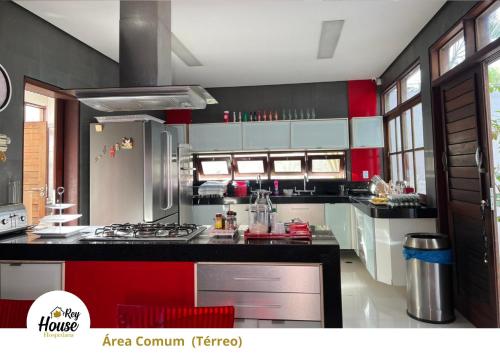 a kitchen with red and black cabinets and a stove at Rey House in Satuba