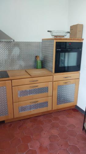 d'une armoire en bois avec un four micro-ondes. dans l'établissement Appartemment meublée, à Frontignan