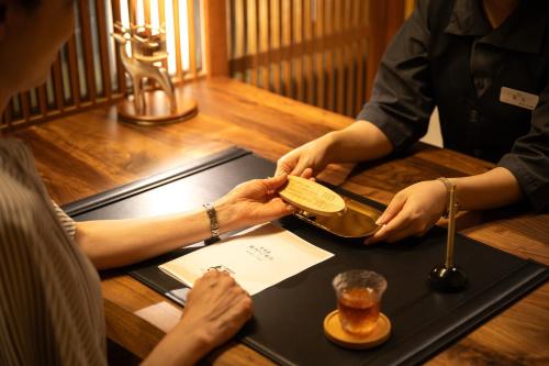 a person is holding a box over a table at Eirakukan in Koriyama