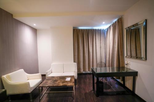 a living room with a couch and a table at Hotel Deccan Serai, HITEC CITY, HYDERABAD in Hyderabad
