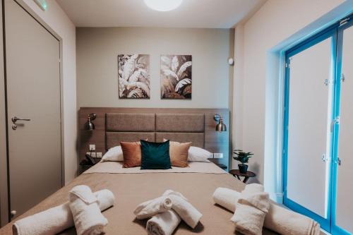 a bedroom with a bed with towels on the floor at Casa Rosanna Malta B&B Adults only 16 plus in Marsaskala