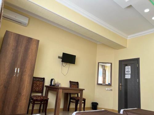 a room with two chairs and a tv on the wall at Rahat Hotel in Ganja