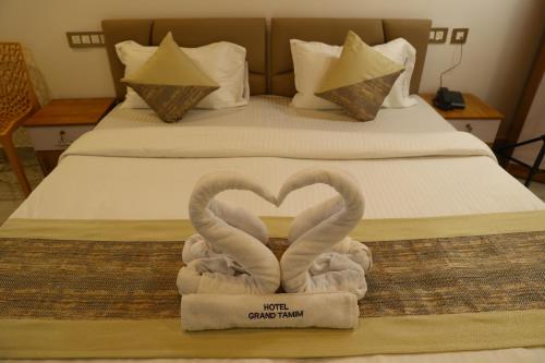 two swans made to look like hearts sitting on a bed at Grand Tamim Hotel in Mangalore
