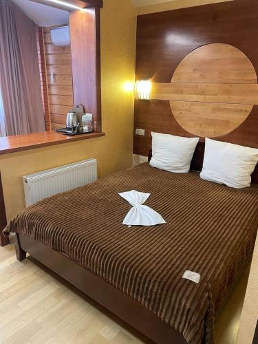 a bedroom with a large bed with a wooden headboard at Готельний комплекс in Babachikha