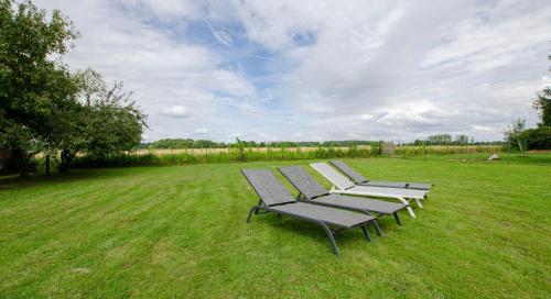 a row of park benches sitting in a field at La petite maison dans lusigny in Lusigny-sur-Barse