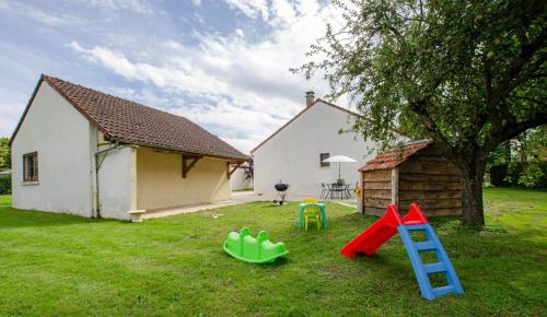 a yard with playground equipment in front of a house at La petite maison dans lusigny in Lusigny-sur-Barse