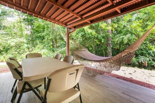 a hammock in a room with a table and chairs at Condo Playa Hermosa, Puntarenas in Muñeco