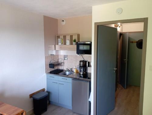 Elle comprend une petite cuisine avec des placards bleus et un évier. dans l'établissement Appartement au Cœur du Col de Rousset, à Saint-Agnan-en-Vercors