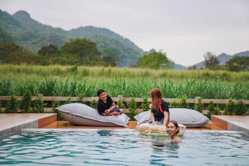 a group of three women sitting in a swimming pool at Club house Khao yai in Mu Si