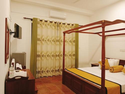 1 dormitorio con cama con dosel y ducha en Hotel Veena, en Pillagoda