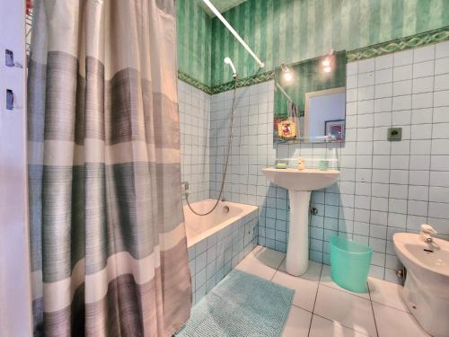 une salle de bain avec un lavabo et un rideau de douche dans l'établissement Nice Promenade, Merveilleuse vue mer, à Nice