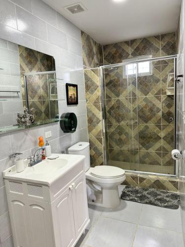 a bathroom with a shower and a toilet and a sink at Villa Tungara in Bejuco