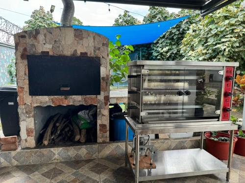 a barbecue grill in front of a stone fireplace at Villa Tungara in Bejuco