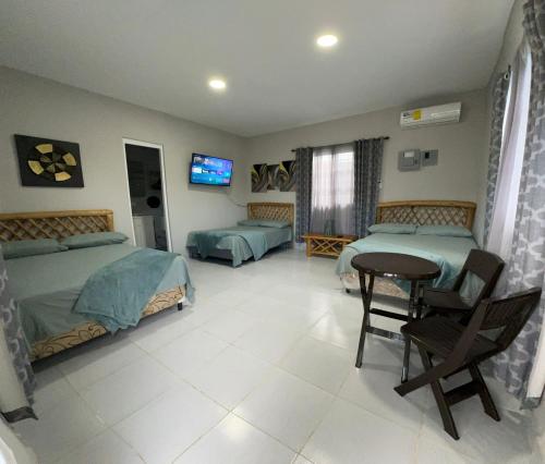 a bedroom with two beds and a table and a tv at Villa Tungara in Bejuco