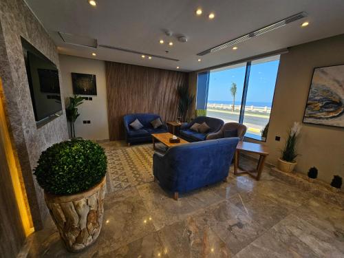 a living room with a blue couch and chairs and a table at فندق سي قل - Sea gull Hotel in Umm Lujj