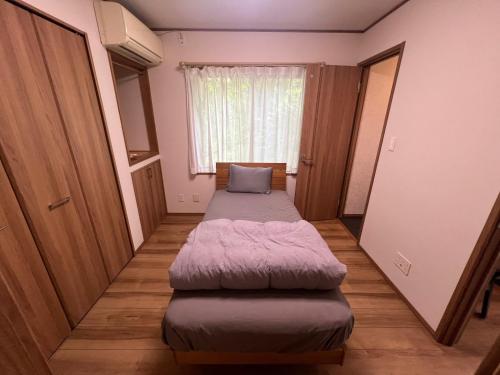 ein kleines Zimmer mit zwei Betten und einem Fenster in der Unterkunft moksa House ヒリゾ浜まで車で10分 in Kanō