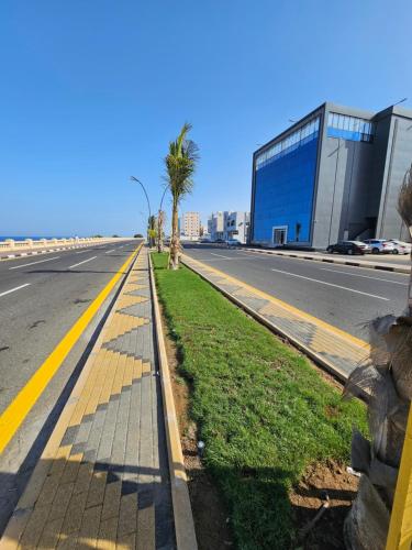 an empty street with palm trees and a building at فندق سي قل - Sea gull Hotel in Umm Lujj