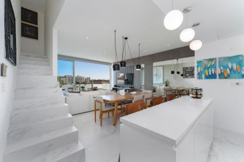 a kitchen and dining room with white walls and white floors at Apartment with Private Rooftop in Medano in Cabo San Lucas