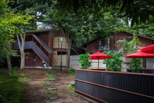 uma casa com guarda-chuvas vermelhos em frente em Fujiyama Inn Conifer em Fujiyoshida