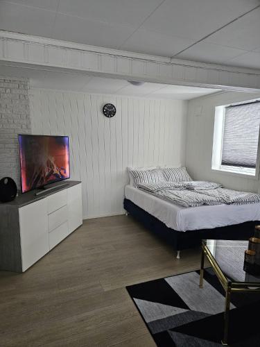 a bedroom with a bed and a flat screen tv at Rooms with free parking in Lillestrøm