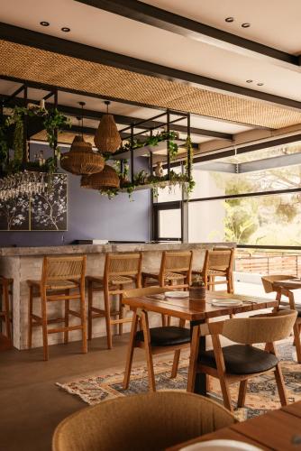 a restaurant with wooden tables and chairs and a bar at Cook's Club Ialysos Rhodes in Ialyssos