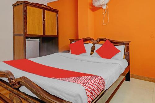 a bedroom with a large bed with red pillows at Hotel O Royal Grand Residency Near Lalbagh Botanical Garden in Bengaluru