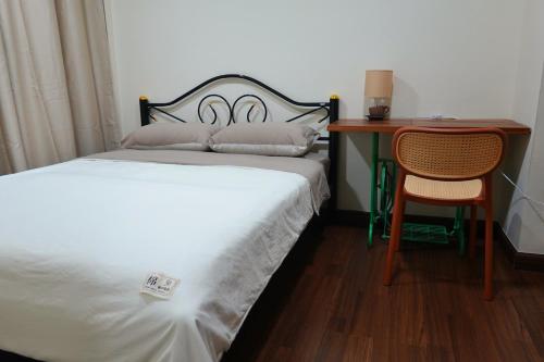 a bedroom with a bed and a desk and a chair at Cozy house in Chiang Mai