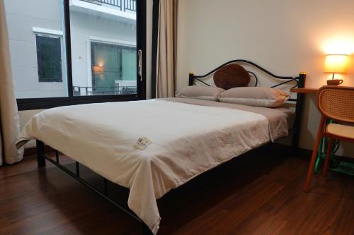a bedroom with a large bed with a window at Cozy house in Chiang Mai