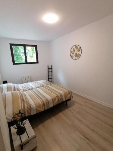 une chambre avec un lit et une horloge au mur dans l'établissement Ô pilotis Appartement avec terrasse et jardin, au Tréport