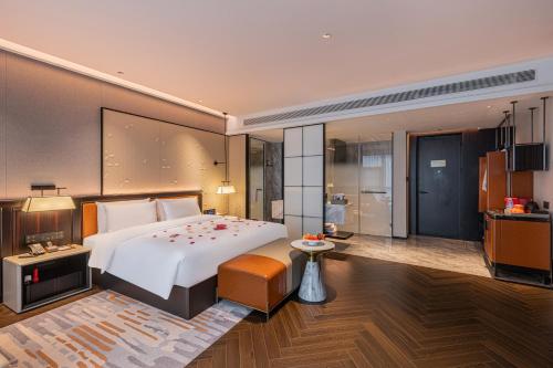 a bedroom with a large bed and a bathroom at Shanghai Maybeours Hotel in Fengxian