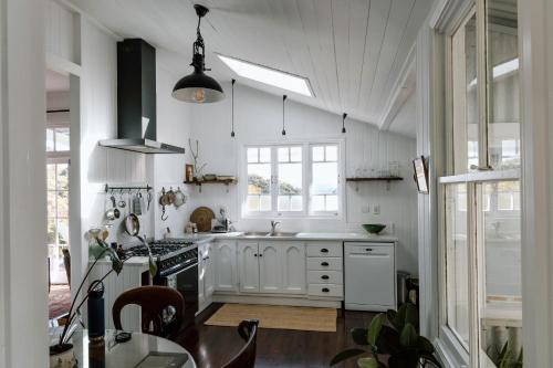 Gracie Cottage Romantic Secluded Hinterland Escape for 2 في مابيلتون: مطبخ بخزائن بيضاء وفرن موقد