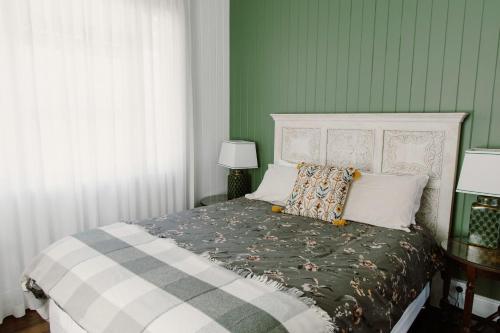 Gracie Cottage Romantic Secluded Hinterland Escape for 2 في مابيلتون: غرفة نوم بسرير مع جدار أخضر