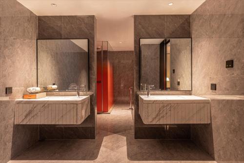 a bathroom with two sinks and a large mirror at Shanghai Maybeours Hotel in Fengxian