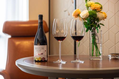 a bottle of wine and two glasses on a table at Shanghai Maybeours Hotel in Fengxian