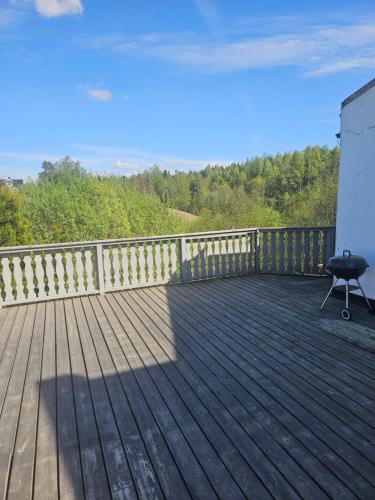 a wooden deck with a grill on top of it at Rooms in Montana Guest house in Lillestrøm