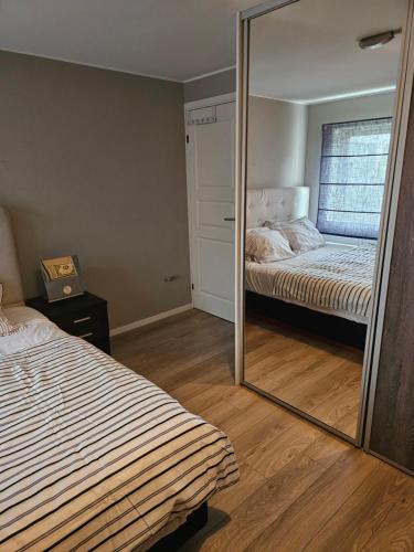 a mirror in a bedroom with a bed at Rooms in Montana Guest house in Lillestrøm