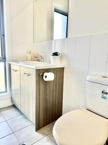 a bathroom with a toilet and a sink at Heartwarming 3BR-Townhouse in Broadview