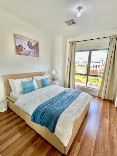 a bedroom with a bed and a large window at Heartwarming 3BR-Townhouse in Broadview
