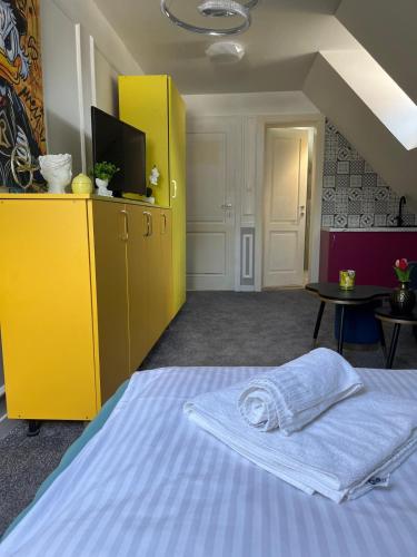 a bedroom with a bed with a yellow dresser and a yellow cabinet at Boutique Hotel Pošta RL in Oravský Podzámok