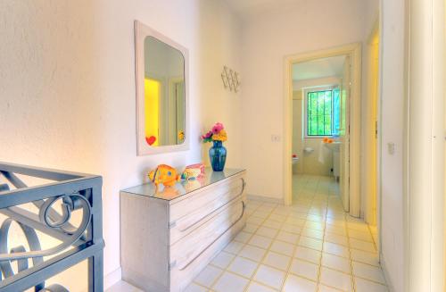 Habitación con tocador con espejo y jarrón en Villaggio Riva Musone, en Porto Recanati