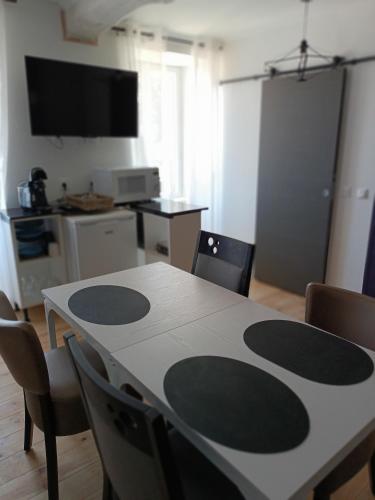 a dining room table with chairs and a kitchen at Les 2 Tours in Chenay