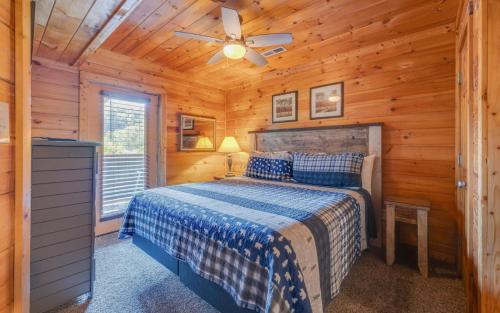 Un dormitorio con una cama y un ventilador de techo. en Heavenly Escape, en Pigeon Forge