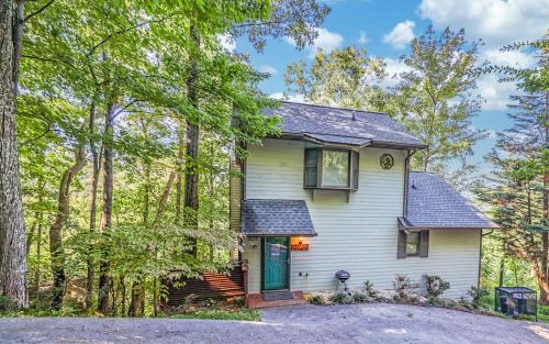 a white house with a green door in the woods at Mountain Bliss in Gatlinburg