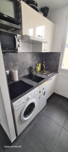 une cuisine avec une machine à laver et un évier dans l'établissement Studio Colombes fonctionnel, à Colombes