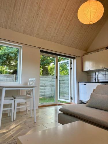 a living room with a bed and a table and a kitchen at Gästhus Abbekås in Abbekås