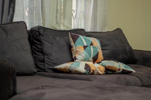 a couch with two pillows sitting on it at Cosy Furnished Home in Kampala