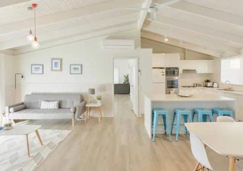 a white living room with a couch and a table at Seaesta Rye by Ready Set Stay - BYO LINEN & TOWELS in Rye