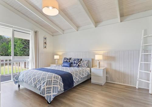 a bedroom with a bed with a blue comforter at Seaesta Rye by Ready Set Stay - BYO LINEN & TOWELS in Rye